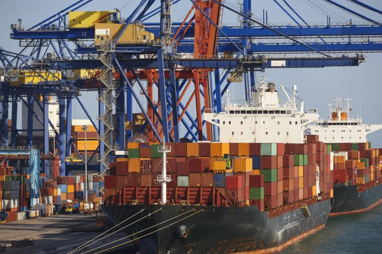 Container ships docked at a port, showcasing HS Agency's logistical solutions and expertise in transportation, shipping, and warehousing services. The image highlights the bustling activity of the shipping industry, reflecting HS Agency's commitment to efficient and reliable logistics across the U.K and Ireland.